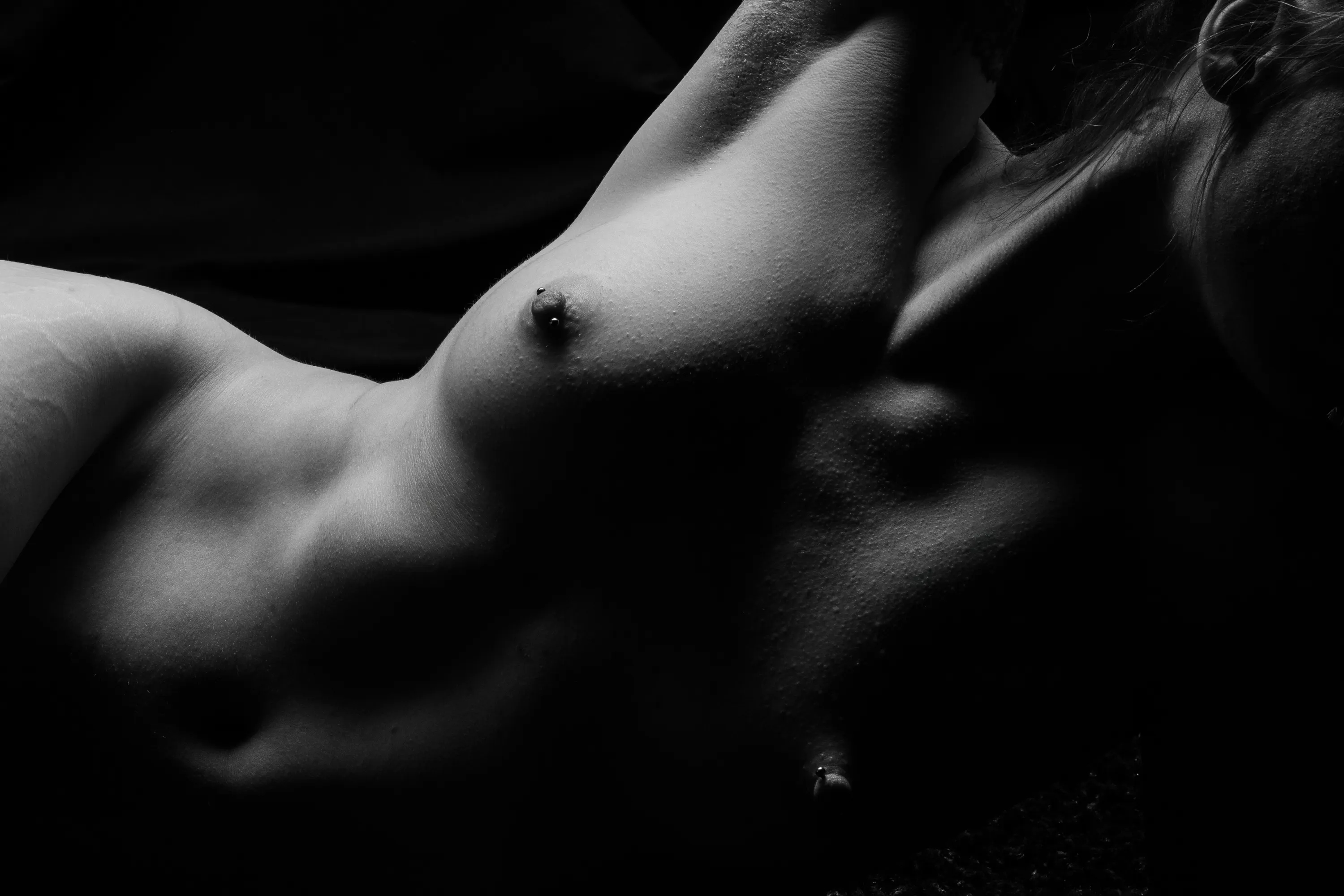 Close-up bodyscape of a woman's upper body as she lies on her side.