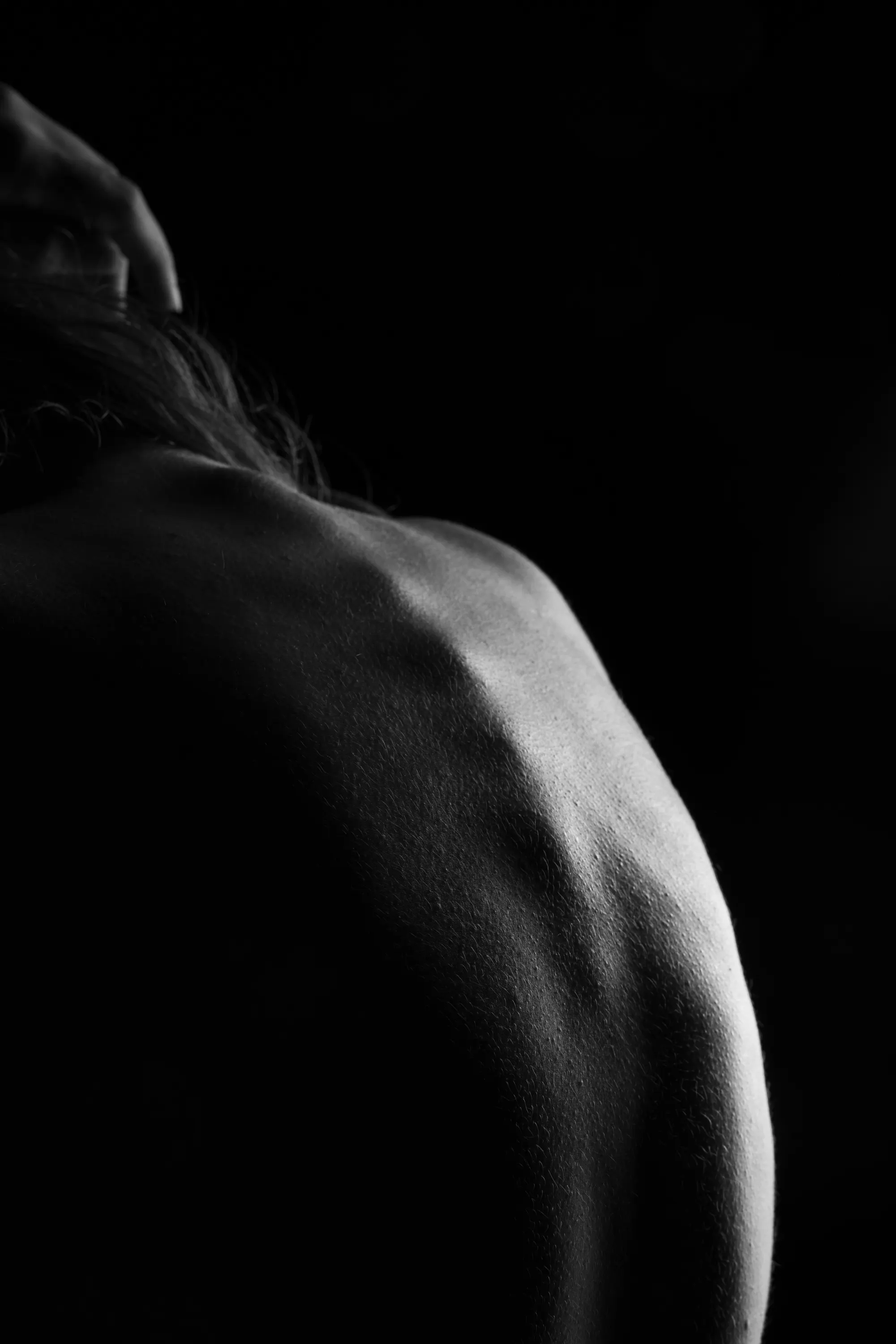 A black-and-white photo of a woman's upper back and spine.