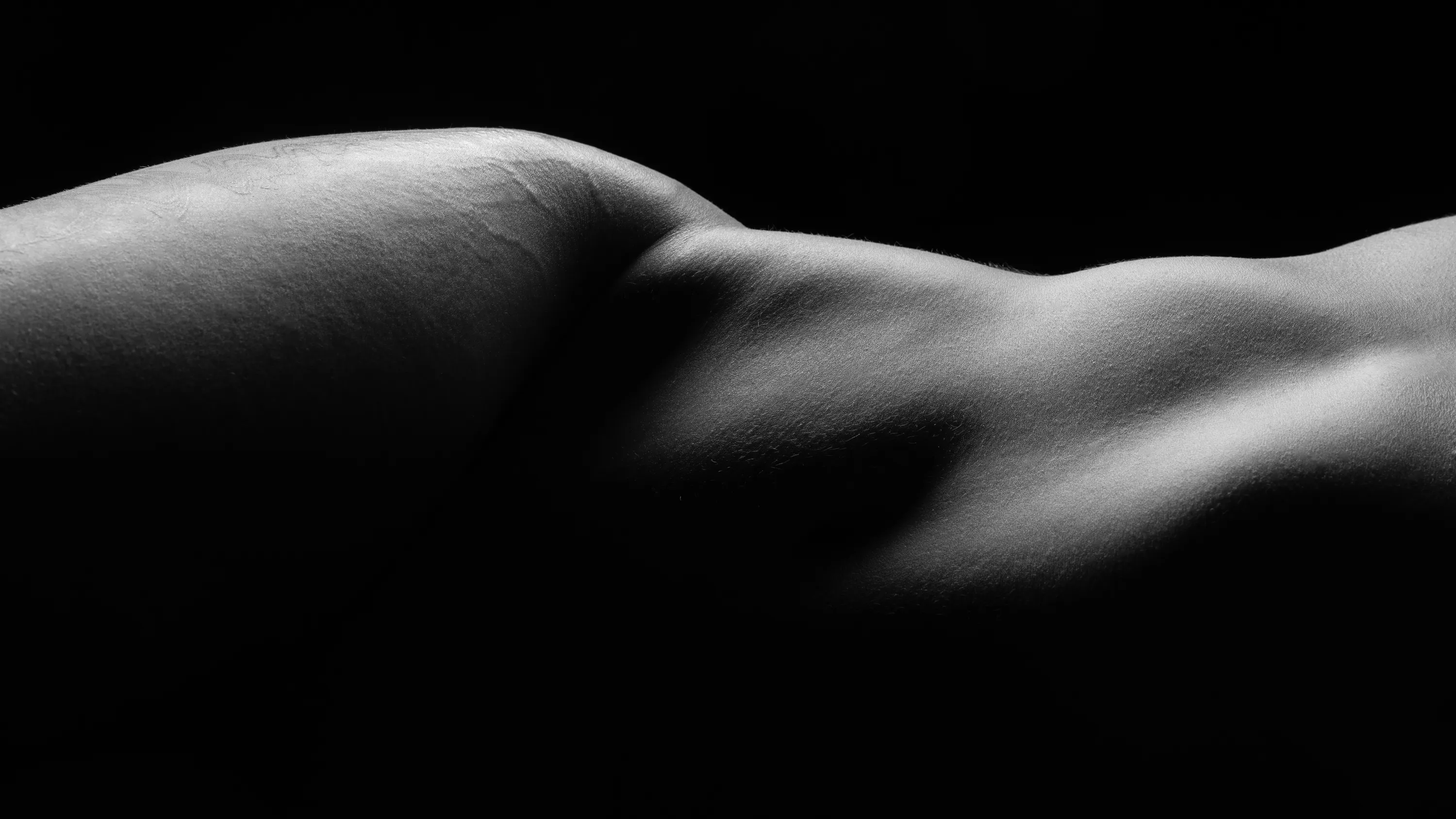 Close-up image of a woman's hip, photographed bodyscape-style in black and white.