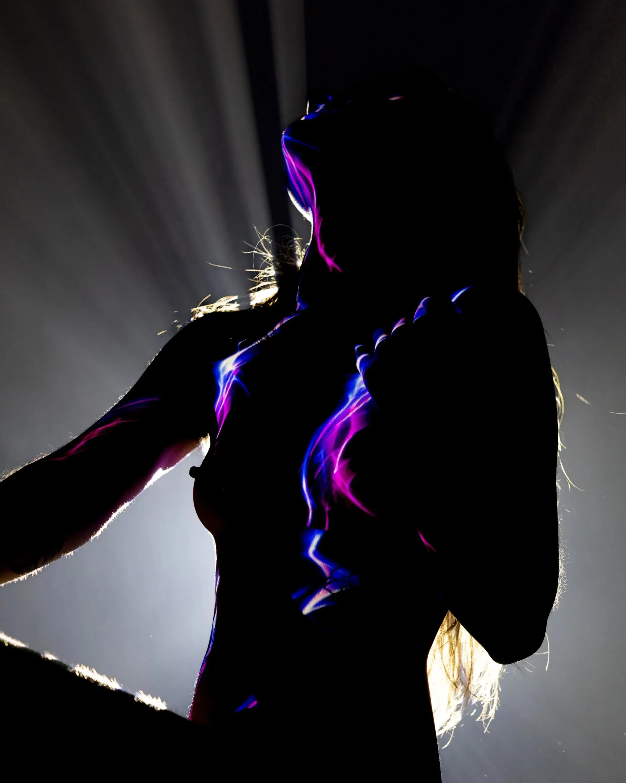 A close silhouette is edged by violet lines and bright backlight.