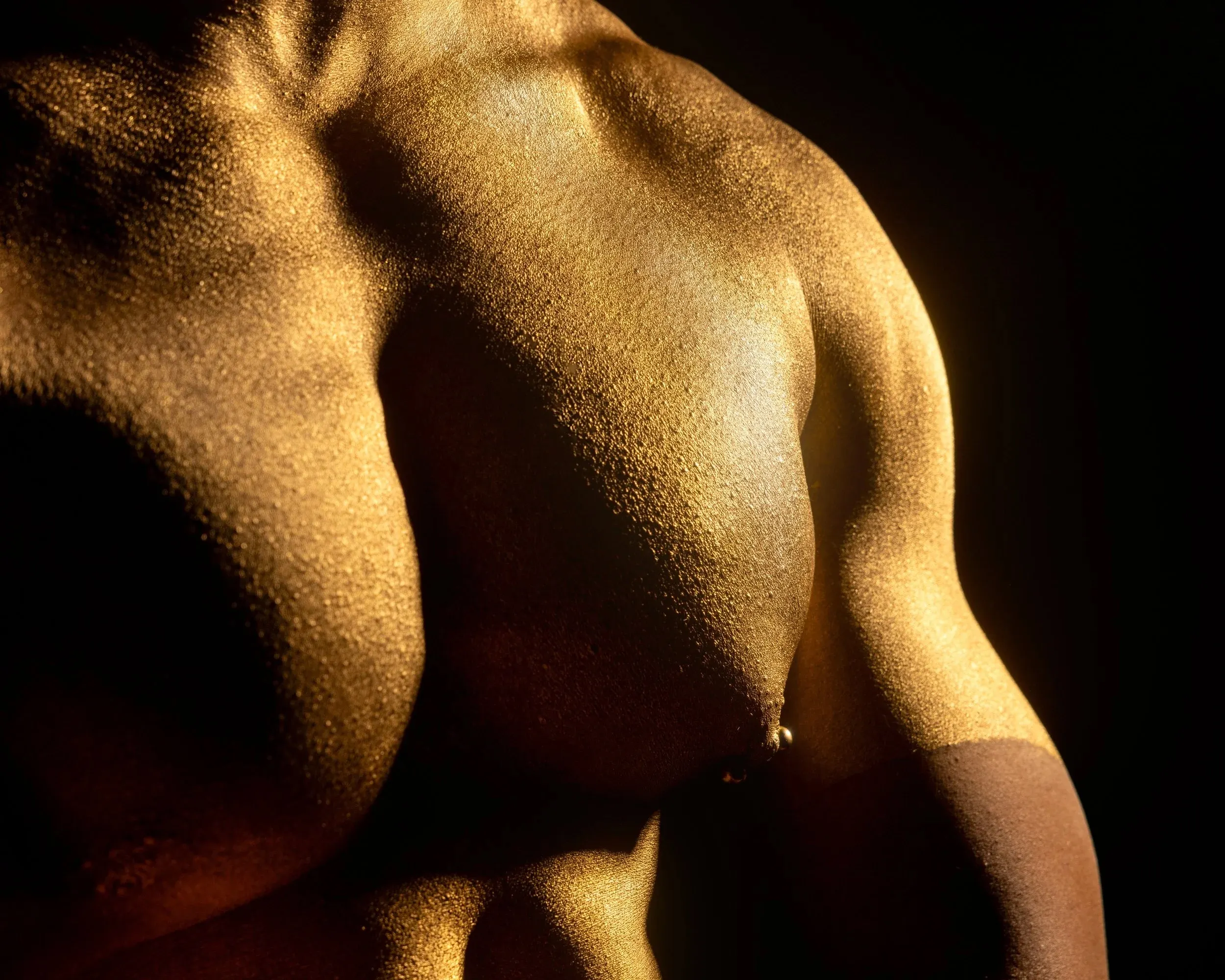 A side-lit gold-painted chest fills a dark horizontal frame.