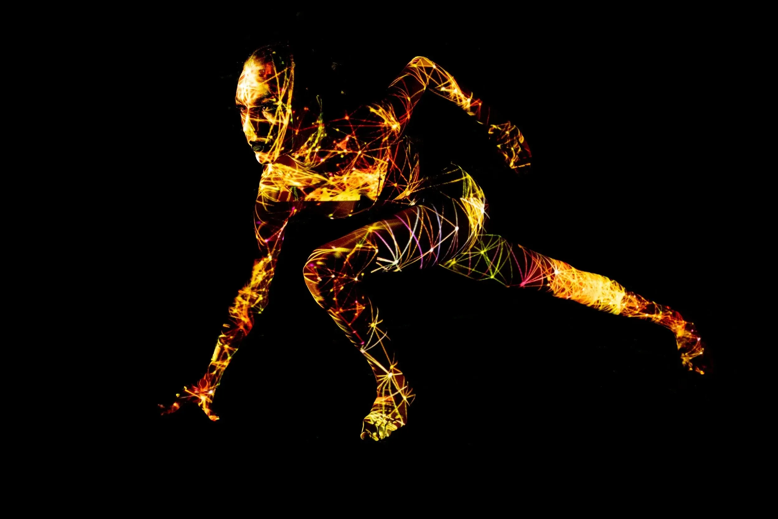 A crouching figure becomes a gold wireframe form against black.