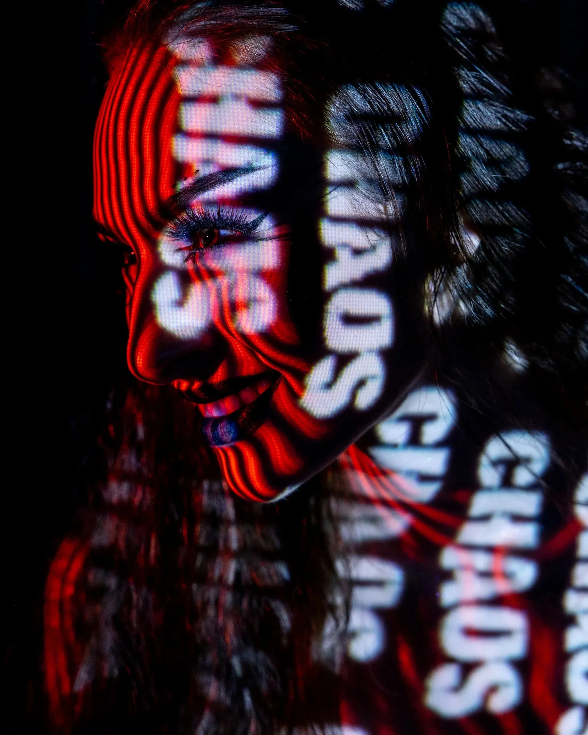 Distorted red and white words wrap across a close portrait.