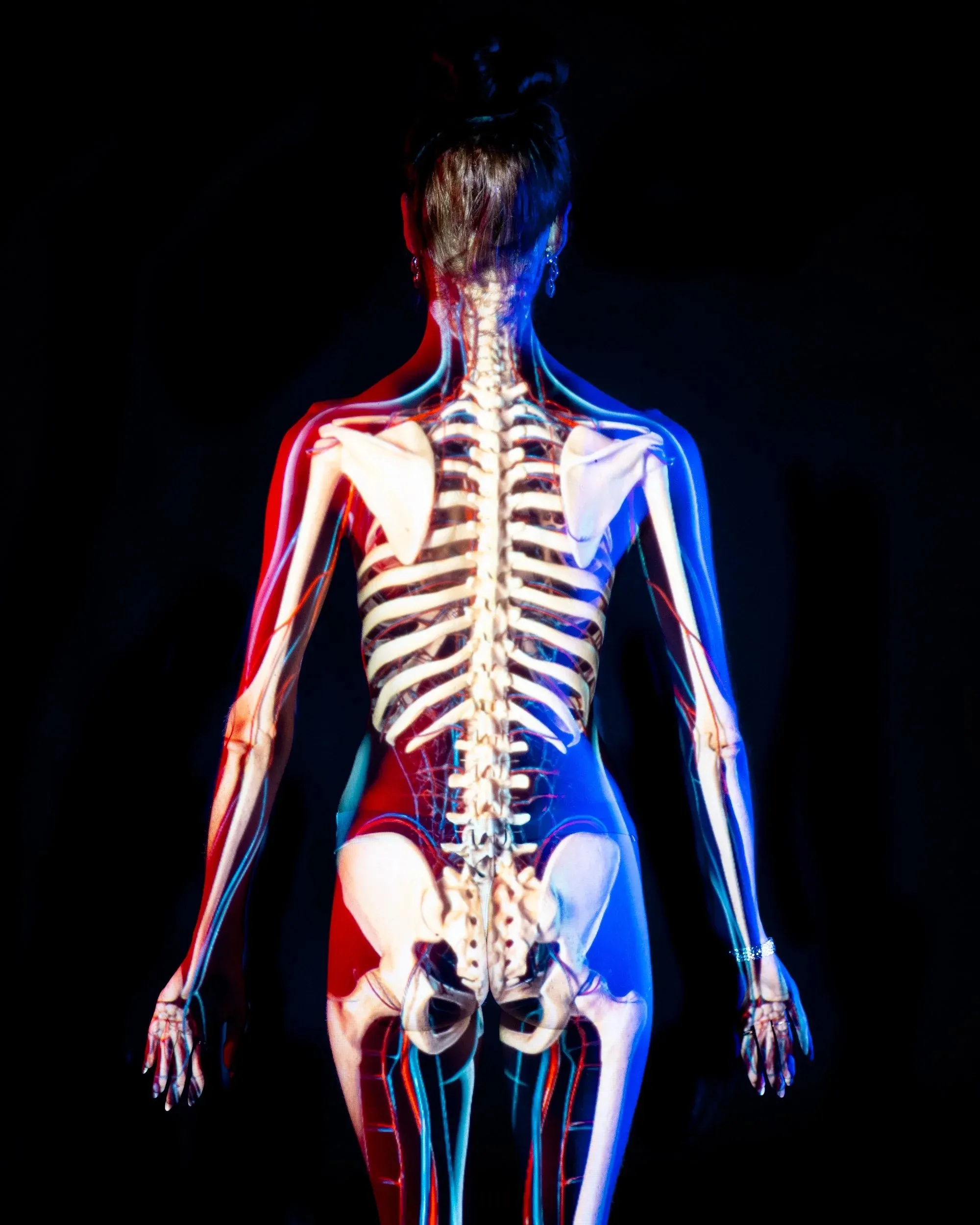A skeleton projection aligns across the back of a standing figure.
