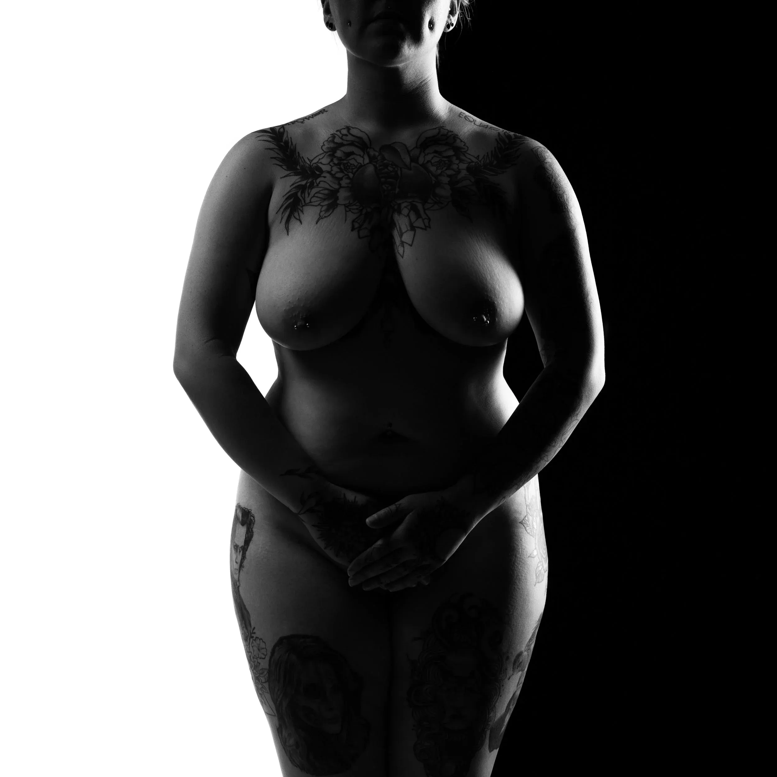 A tattooed standing figure is silhouetted against a bright white background.