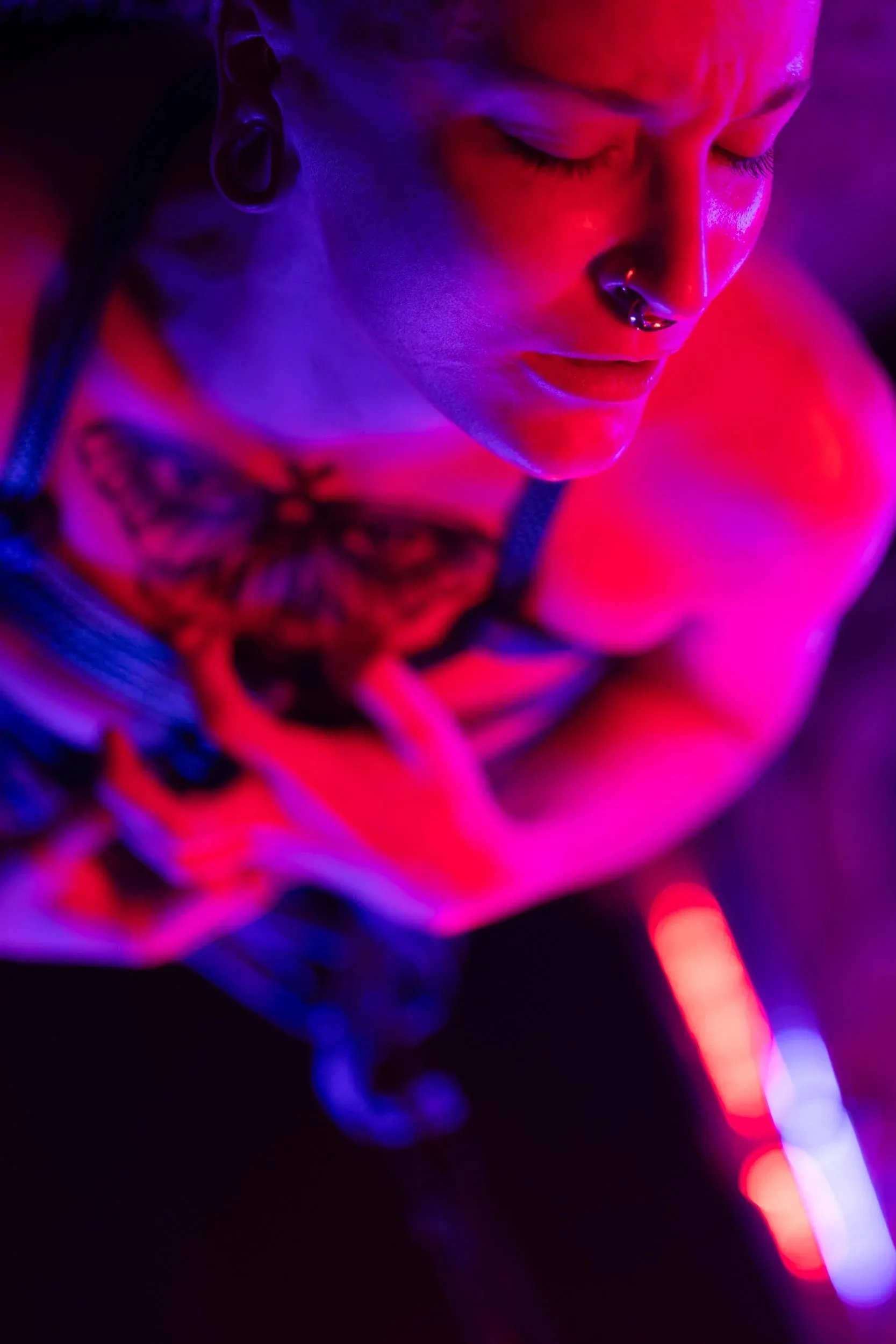 A person looks down while gathering rope beside a glowing tube.