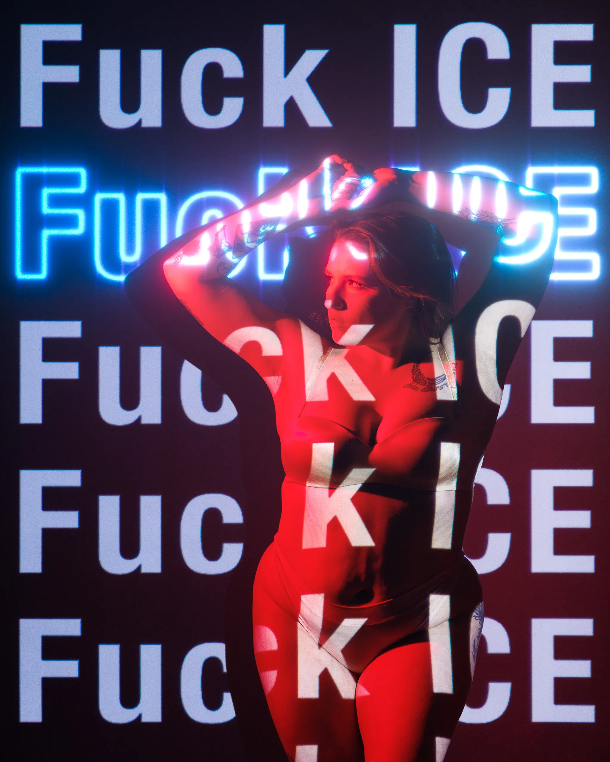 A woman poses with her arms raised as the words 'Fuck ICE' are projected onto her body and the background.