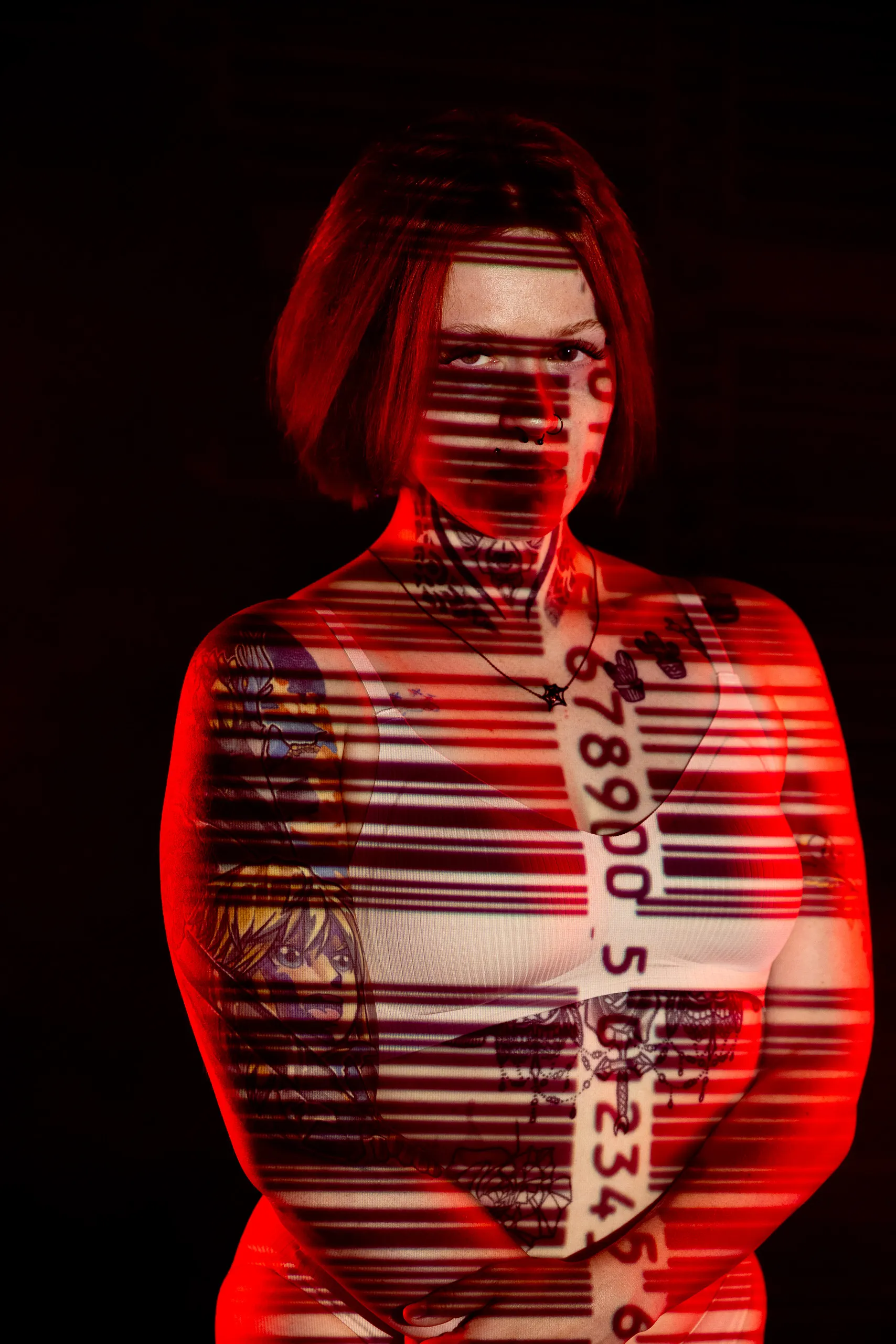 A woman faces the camera with red and white barcode lines and numbers projected across her face and body.