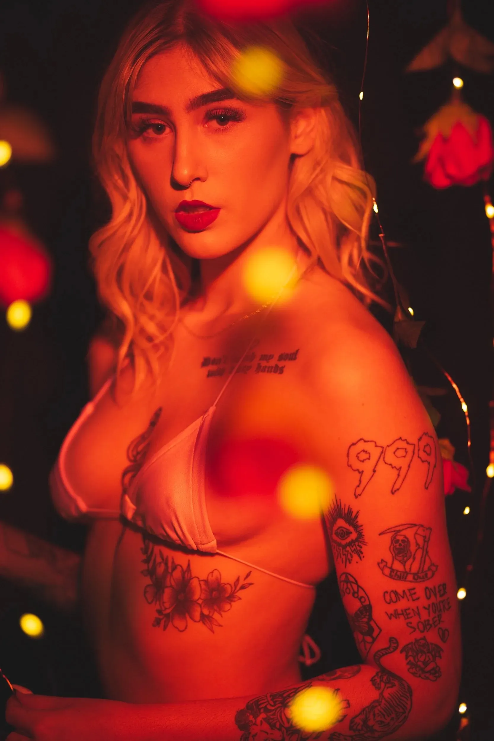 A vertical portrait layers a woman with red roses and floating gold lights.