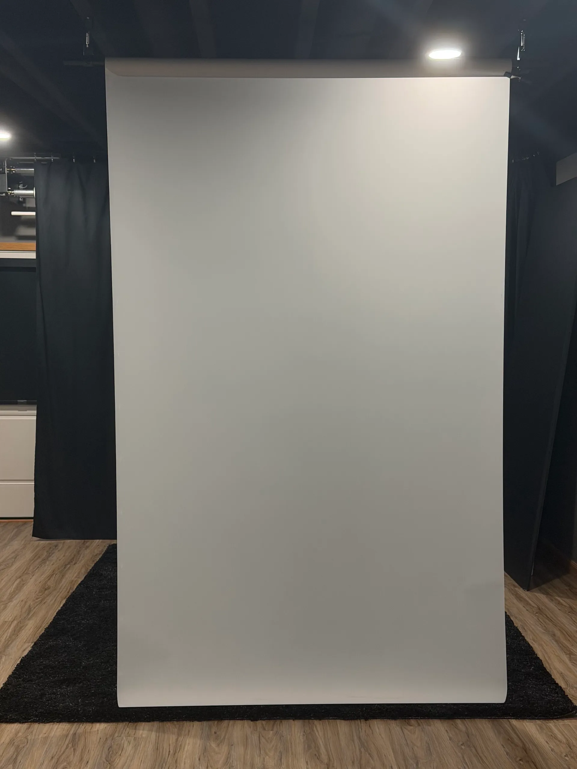 A roll of white Translum backdrop hanging in a photography studio.