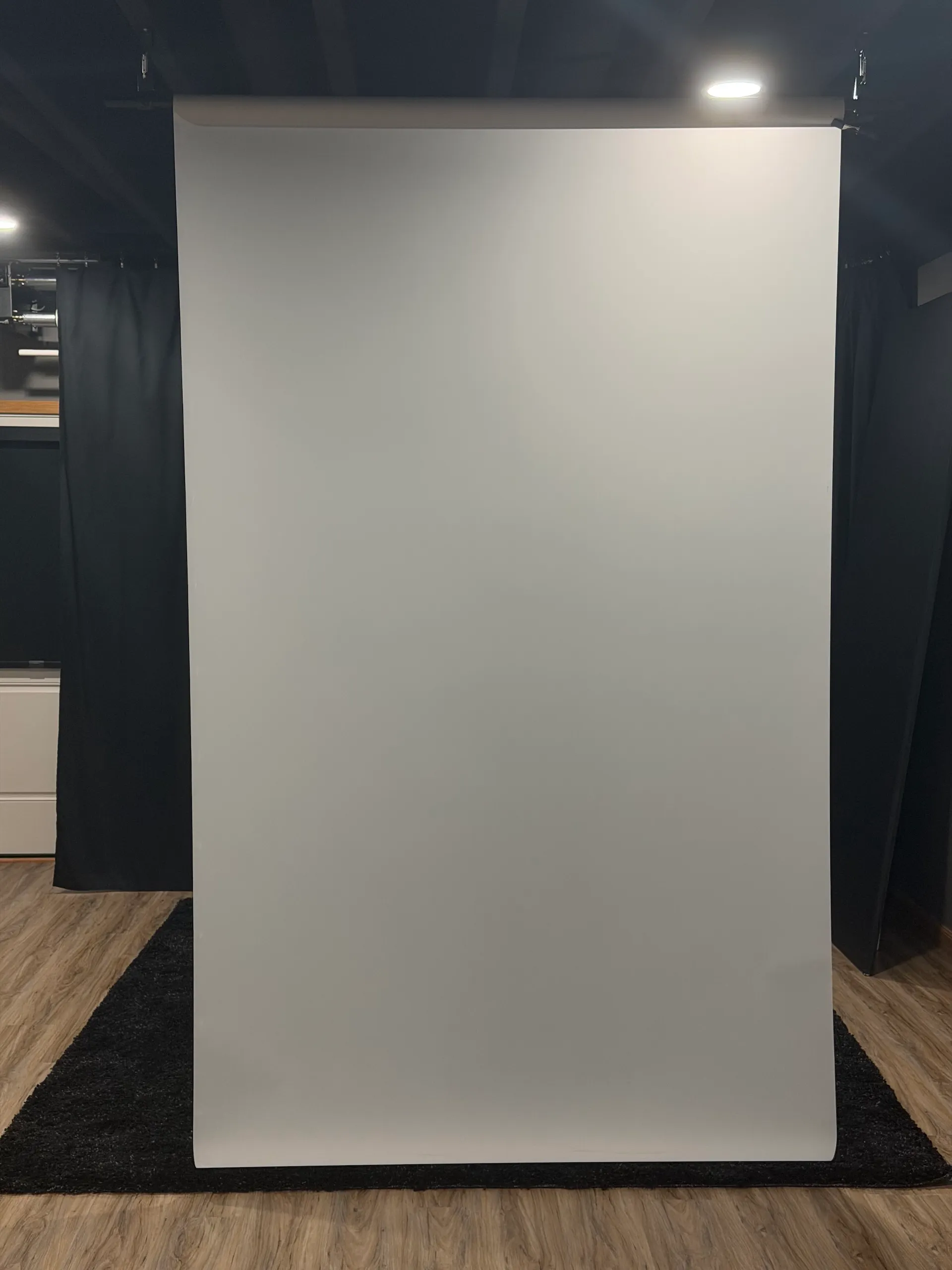 A roll of white Translum backdrop hanging in a photography studio.